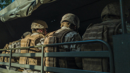 Military personnel riding in transport.
