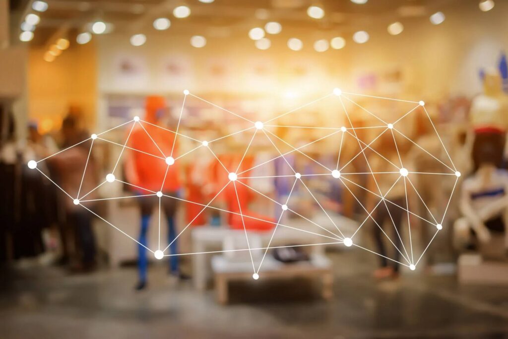 Illustration of interconnected illuminated dots against a blurred background of a retail space.