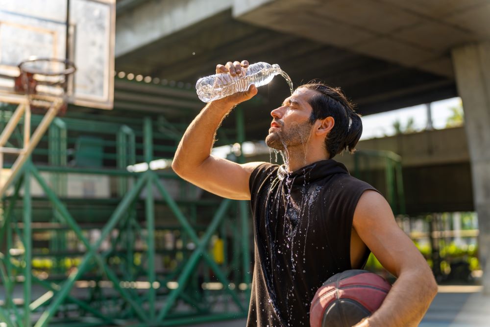 Athlete douses himself with water on a hot day.