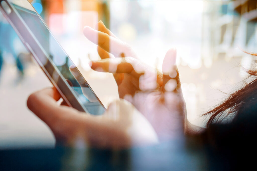 Person using a smartphone with soft, blurred reflections, representing mobile accessibility in everyday environments.